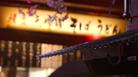 Close-up-of-rain-falling-on-rooftop-inside-narrow-alley-in-Japan