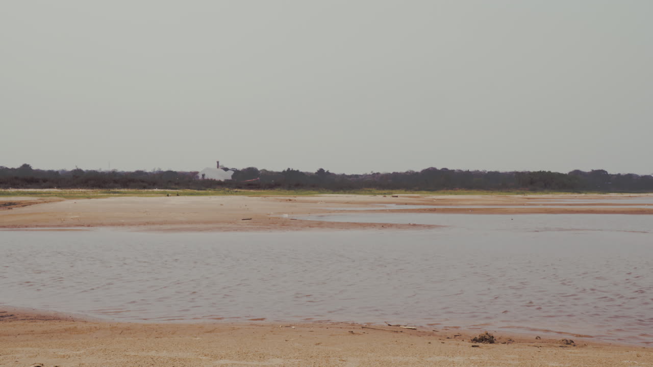 Low Water Levels in Riverbed: Drought and Environmental Impact. Low water levels, exposing sandy and barren patches. A sense of vulnerability in natural resources