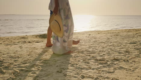 a young couple is walking barefoot on the sand on the beach in the frame only the legs are visible v