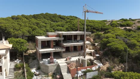luxury home under construction with crane on hillside in majorca, spain