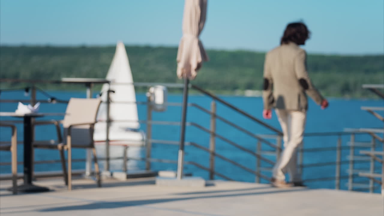 Chisinau, Moldova - June 17, 2025: Elegantly dressed man and woman walking on a scenic terrace with a view of a calm body of water