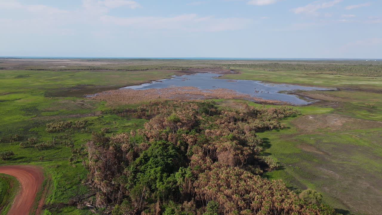 disparo de drones en alto movimiento de pantano verde y agua azul cerca del parque natural de la selva de holmes, darwin, territorio del norte