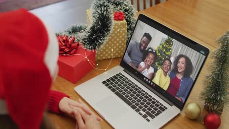 Kaukasische-Frau-Führt-Weihnachtsvideoanruf-Auf-Laptop-Mit-Afroamerikanischer-Familie-Auf-Dem-Bildschirm