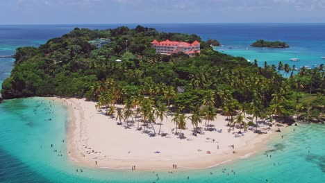 Los-Turistas-Nadan-En-El-Idílico-Mar-Caribe-Frente-A-La-Playa-De-Arena-Tropical-De-La-Isla,-Drone