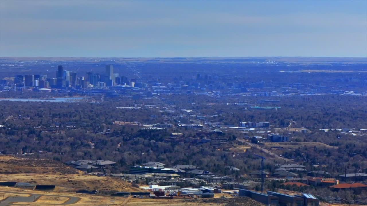 Downtown Denver cityscape from Lookout Mountain Golden North Table Mesa aerial drone Colorado daytime winter sunny clouds neighborhood Front Range Rocky Mountains Arvada Lakewood pan left motion