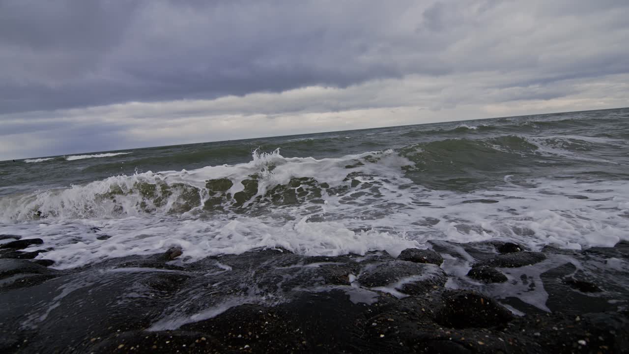 A wave crashes onto the rocks at Domburg beach in Zeeland, Netherlands, in super slow motion