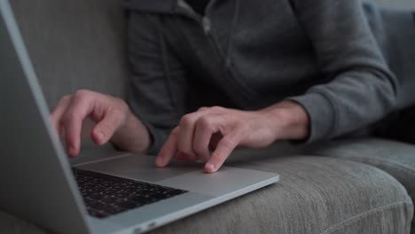 Man-working-from-home-on-his-laptop-while-lying-on-the-couch