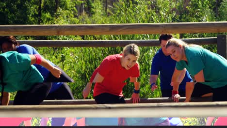 trainer assisting women in during obstacle course