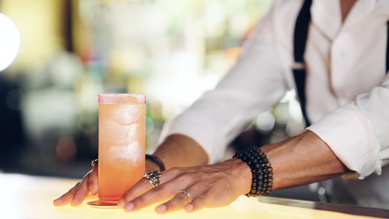 Bartender's Hands Pushing a Refreshing Cocktail Drink on a Bar Counter