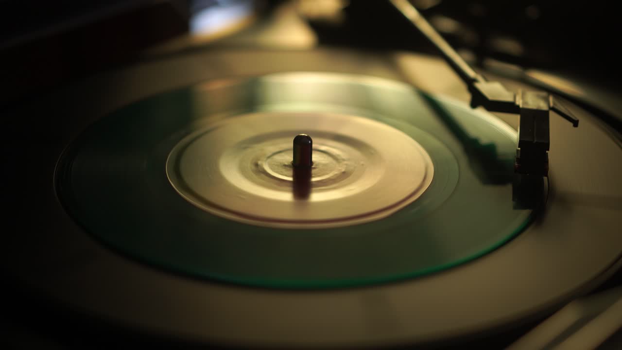 Start af afspilning af enkelt grøn vinylplade, nærbillede.
