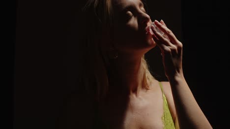 sensual woman touching her face with ice cubes