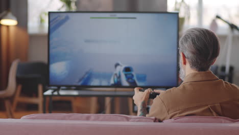 man playing shooter video game on tv at home