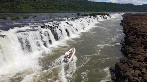 aerial view passing over semirigid boat going up against the strong streams of moconá waterfalls