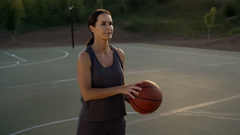 woman playing basketball on an outdoor court