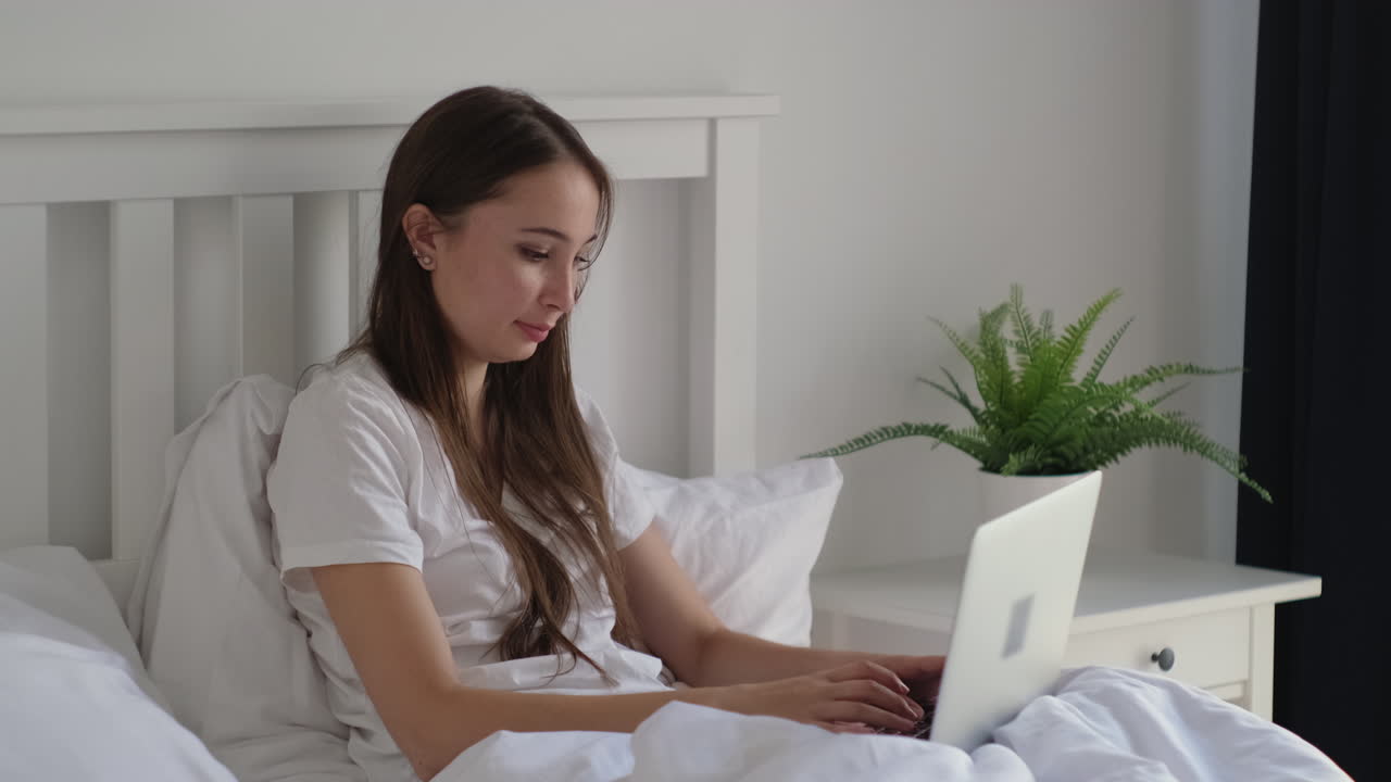 침대에 노트북을 사용하는 여자