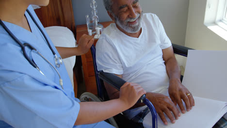 High-angle-view-of-blind-senior-black-man-sitting-on-wheelchair-and-reading-braille-book-at-home-4k