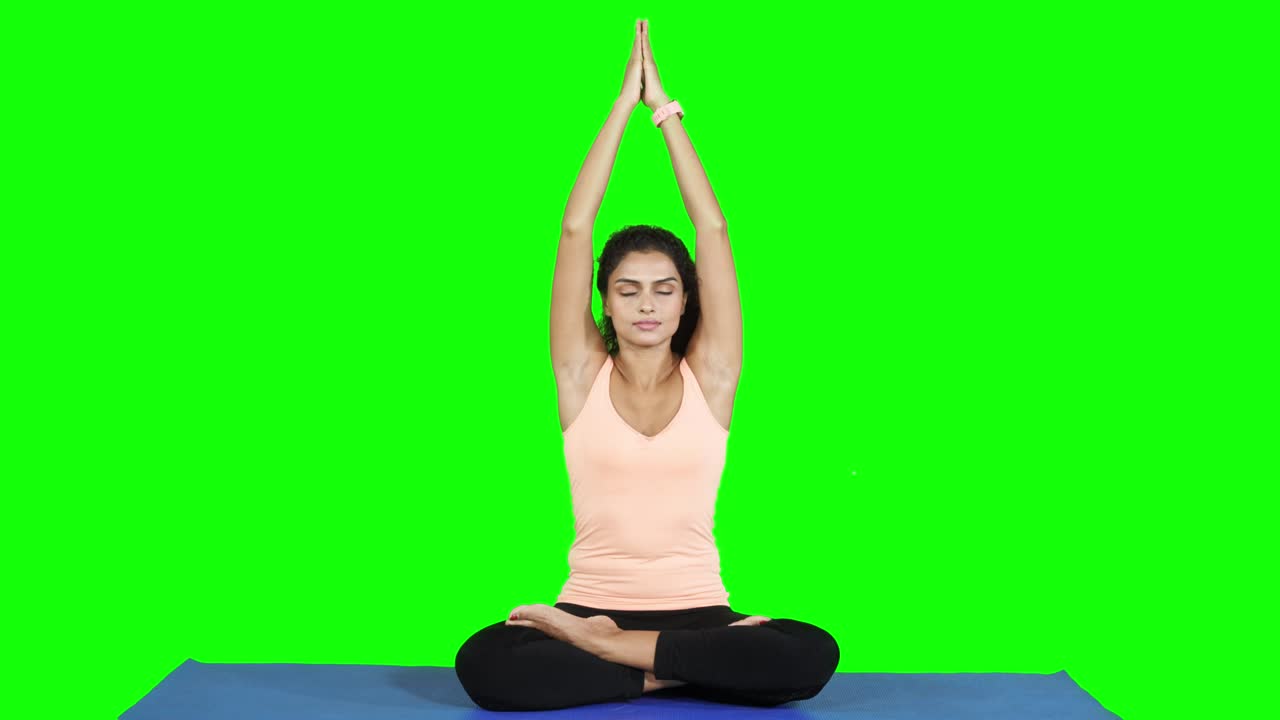 mujer haciendo ejercicio de yoga meditando en el estudio