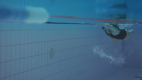 underwater shot of woman swimming in indoor pool