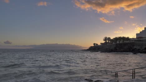 beautiful sky over shoreline with sea wall and buildings lining the coast