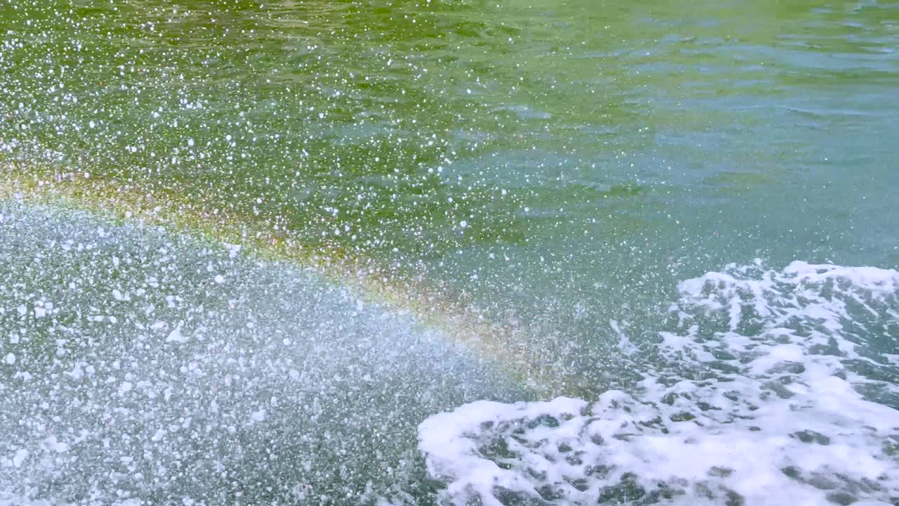 배는 운하에서 스프레이와 무지개를 만니다.