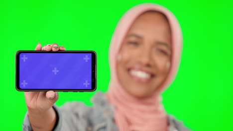 woman holding phone on green screen