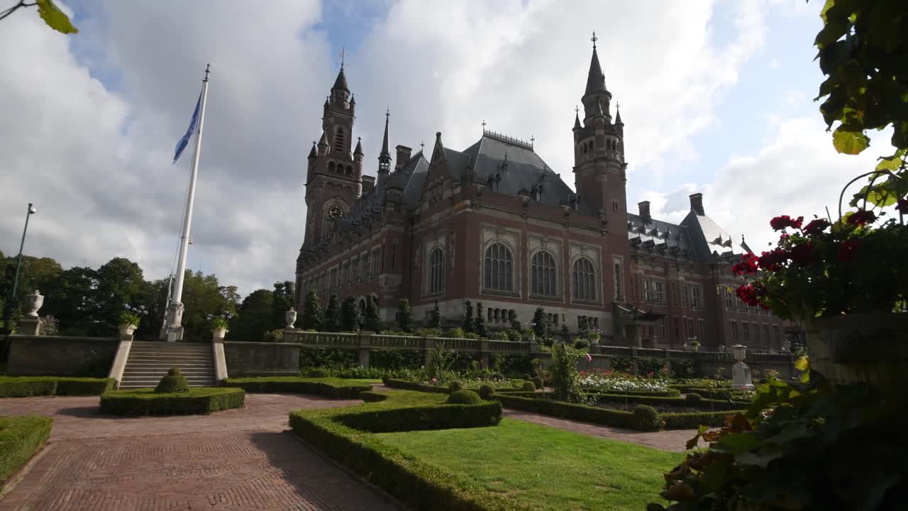 Garden of the Peace Palace, the seat of the International Court of Justice under a sunny and cloudy summer day.
