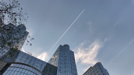 contrail crosses sky above eu parliament towers in brussels