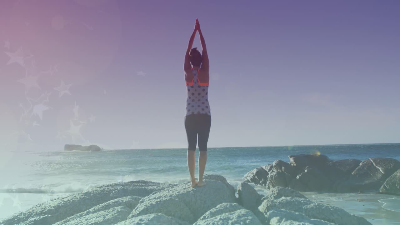 바 ⁇ 가에서 요가를 연습하는 두 인종의 여성 위에 반 ⁇ 이는 불빛의 애니메이션