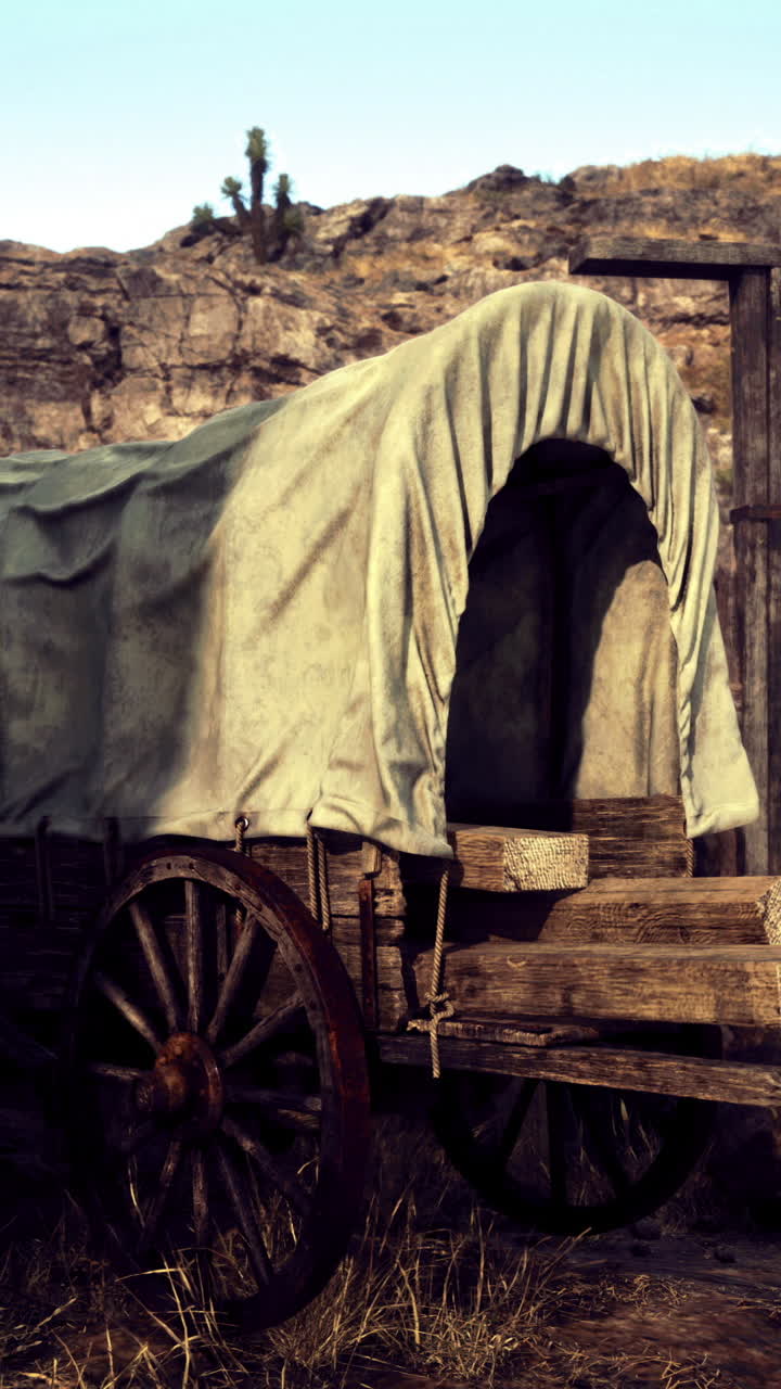 Old wagon at a rustic wooden gate in a desert setting during daylight hours