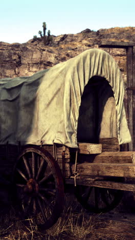 old wagon at a rustic wooden gate in a desert setting during daylight hours