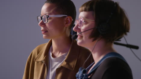 female film director and assistant shooting movie or video discussing scene in studio shot in real time