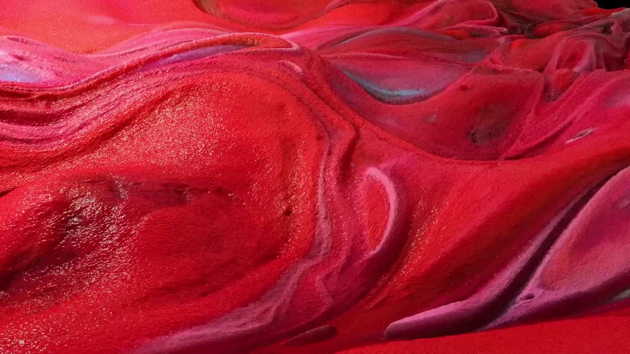 Macro abstract animation of viscous red and pink paint or liquid swirling and mixing slowly. Organic, textured, and artistic motion background
