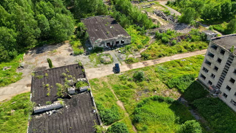 Edificios-Abandonados-En-Una-Zona-Cubierta-De-Maleza-Vistos-Desde-Arriba.