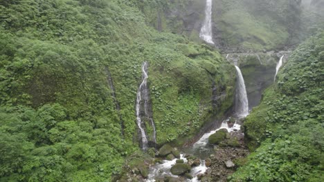 move in close drone shot into a waterfall in the jungle costa rica