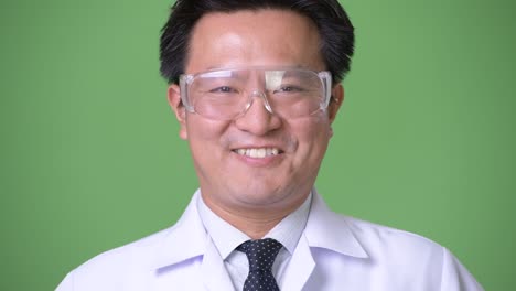 mature japanese man doctor wearing protective glasses