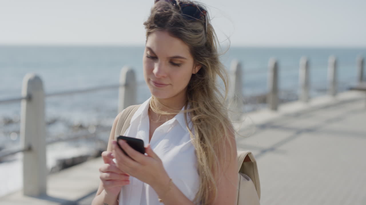 porträt junger, schöner frau, touristin mit samrtphone, die fotos von sonnigem meer am handy macht. kamera, die sightseeing, sommerurlaub und slow motion genießt