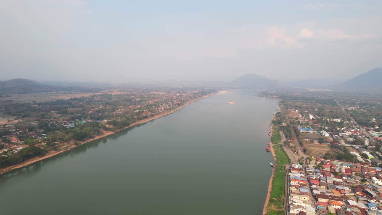 una foto aérea exótica de una mañana brumosa en el distrito de chiang khan con el paisaje del río mekong en tailandia, un avión no tripulado volando hacia atrás