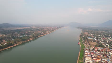 Toma-Aérea-Exótica-De-Una-Mañana-Brumosa-En-El-Distrito-De-Chiang-Khan-Con-El-Paisaje-Del-Río-Mekong-En-Tailandia,-Drones-Volando-Hacia-Atrás