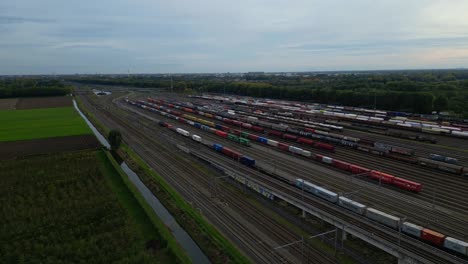 Luftaufnahme-Des-Buckelhofs-Kijfhoek-Mit-Waggonzug,-Der-An-Geparkten-Waggonzügen-Vorbeifährt