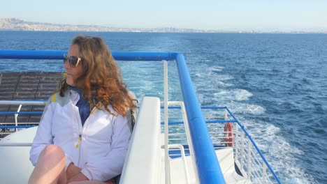 beautiful view of the mediterranean sea with young woman on a boat ride leaving naples, italy