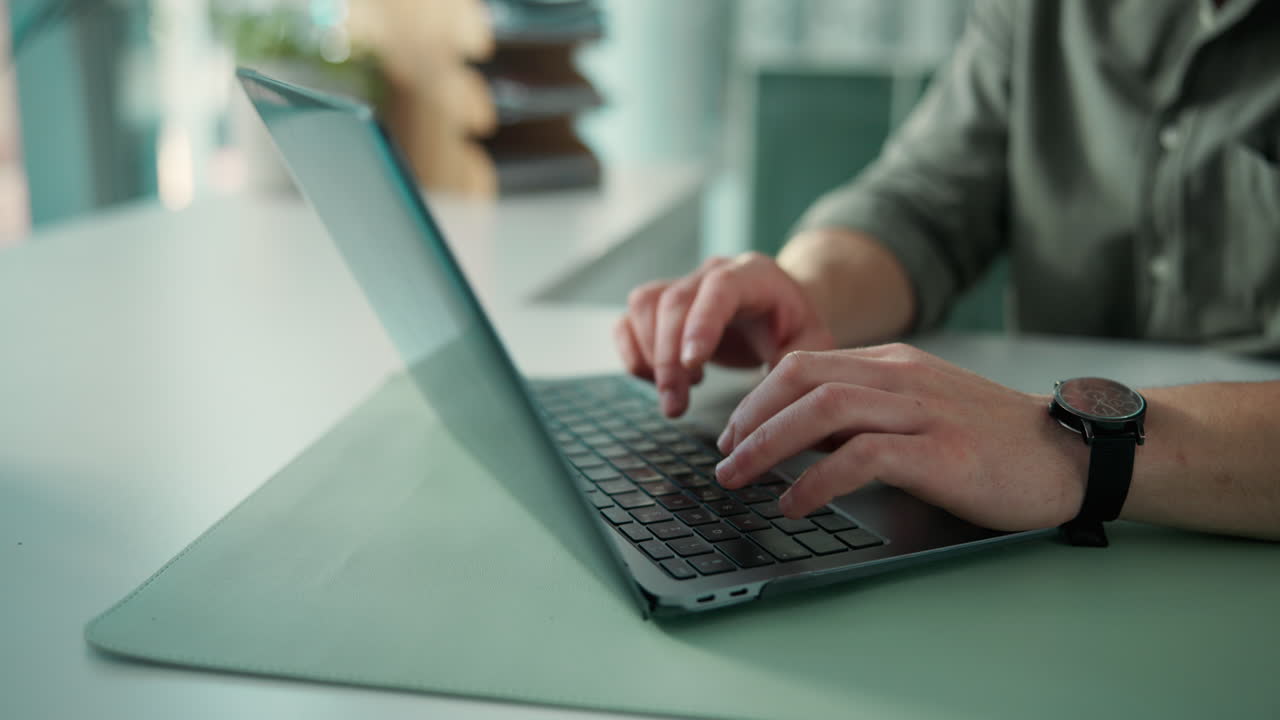Man's Hands Typing on Laptop Keyboard in Office