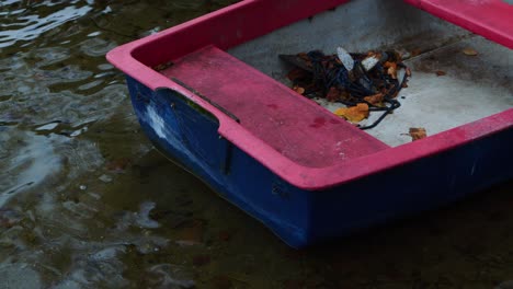 un bote rojo en la orilla del agua en la naturaleza