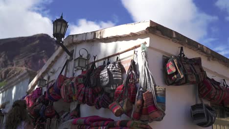 vibrant handmade bags and textiles on display at an outdoor market