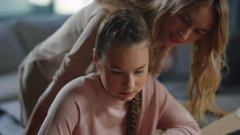 Daughter-doing-homework-next-to-mom.-Child-studying-remotely-with-computer.