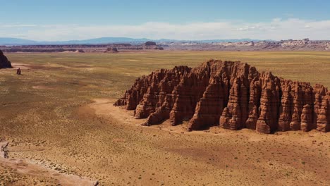 a beautiful aerial drone shot of a stunning desert scene with orange sand and large red rock formations in utah