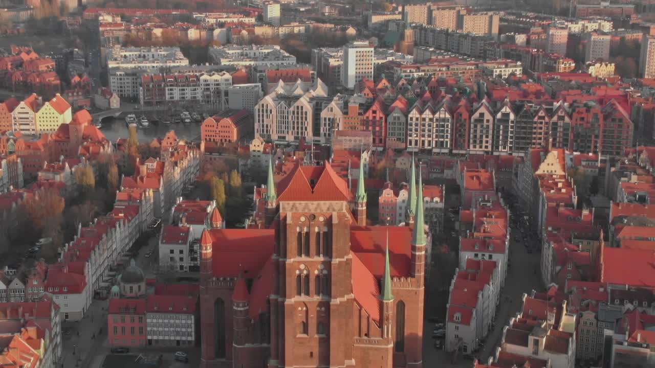 Historický cihlový kostel v Gdaňsku, Polsko s červenými střechami na podzim