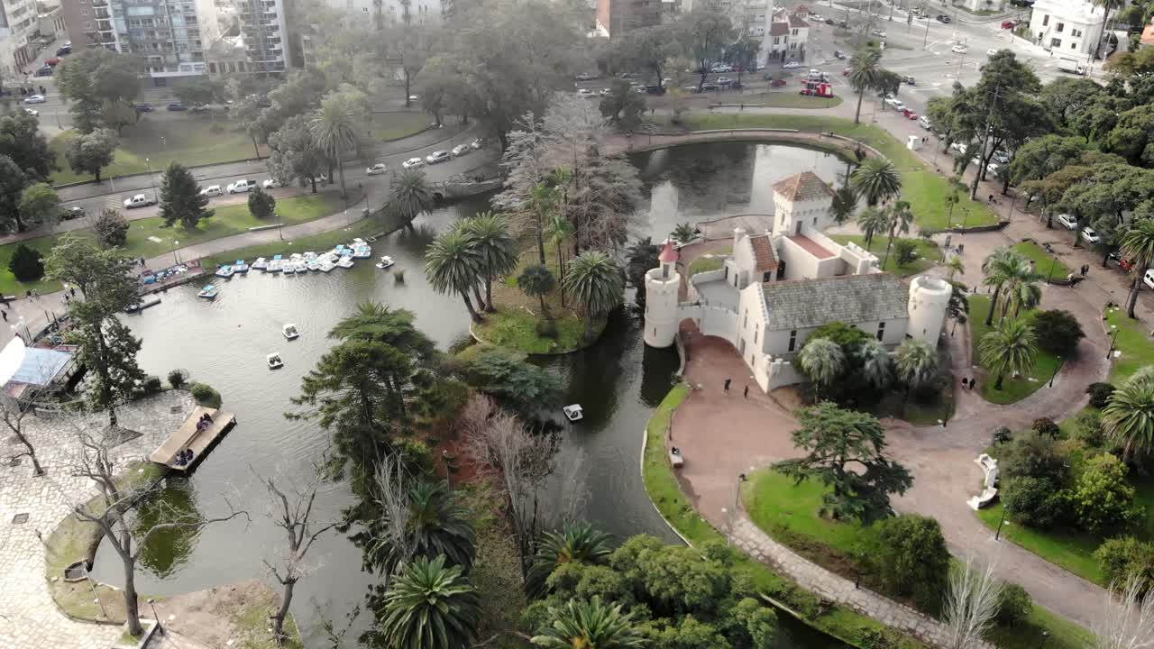 vista aérea del lago del parque con barcos y el castillo al fondo