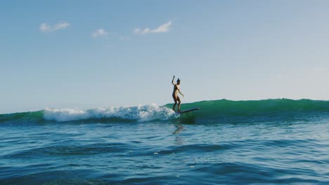 young woman surfing at sunset