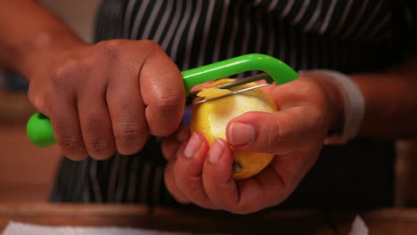 Hands-seen-peeling-the-bitter-rind-off-a-lemon---close-up,-isolated,-slow-motion