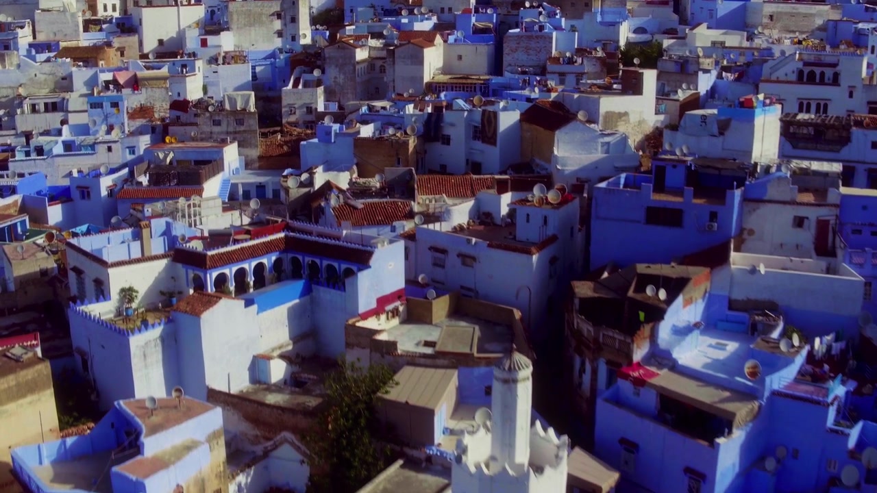 Drone descends and pulls back over Chefchaouen, revealing a white minaret.